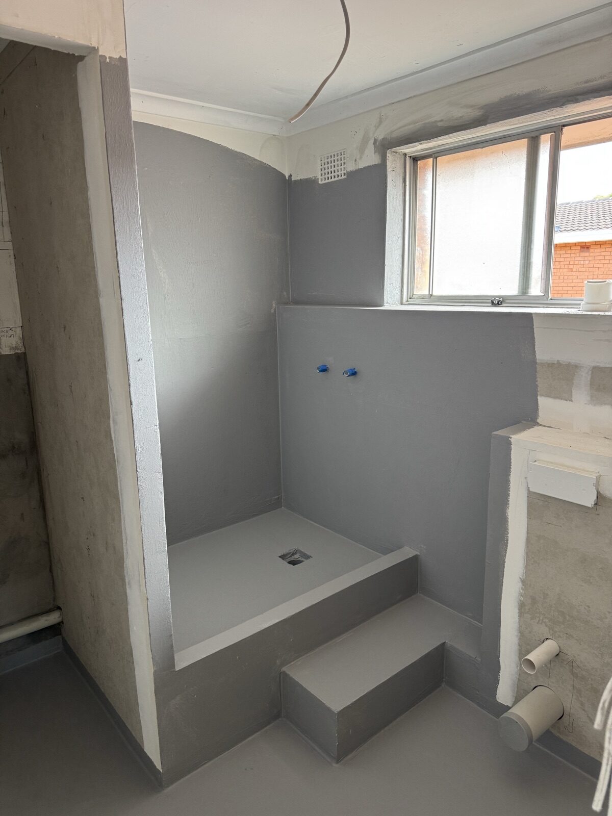 Waterproofed shower recess with constructed hob and nib wall, Class 2 apartment renovation in Stanmore